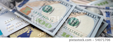 Huge amount of US banknotes lying at table among passport banking cards and financial report 54071706