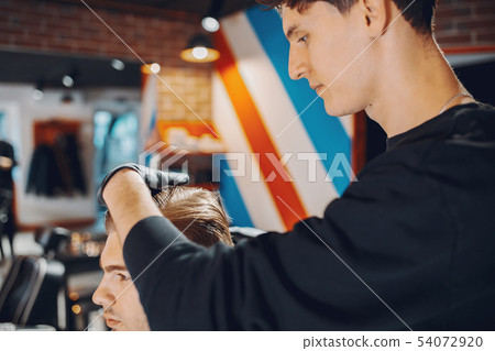 Stylish man sitting in a barbershop Stylish man sitting in a barbershop 54072920
