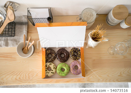 Box with doughnuts on table 54073516