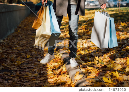 autumn fun man shopping bags fall leaves sidewalk 54073930