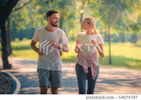 Portrait of Young couple running in the park at Portrait of Young couple running in the park at 54074787