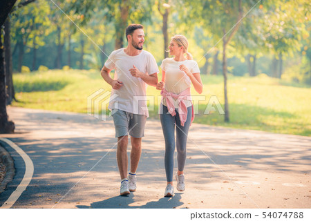 Portrait of Young couple running in the park at 54074788