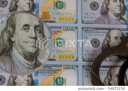 100 US dollars banknotes under magnifying glass 100 US dollars banknotes under magnifying glass 54075230