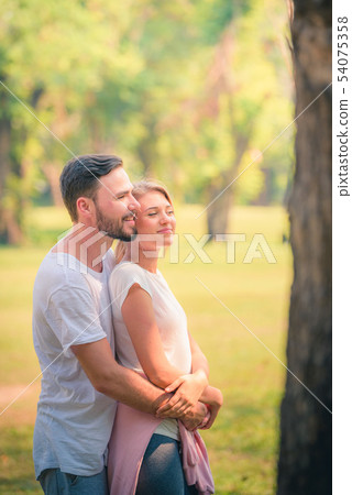 Portrait of Young couple enjoying in the park at s Portrait of Young couple enjoying in the park at s 54075358