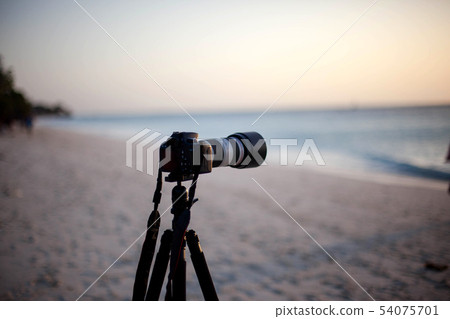 Digital camera on a tripod seashore to shoot sunse 54075701