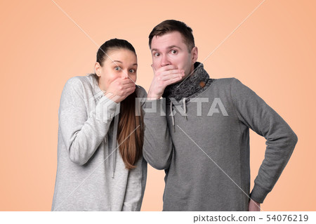 man and woman laughing and covering mouth with hand 54076219