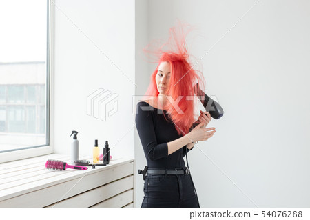 Hairdresser, style, people concept - woman is blowing dry her colored hair 54076288