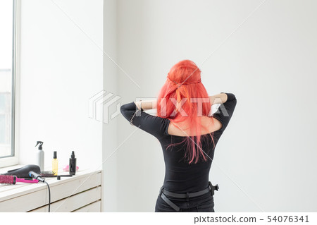 young beautiful woman combing her hair in living room 54076341