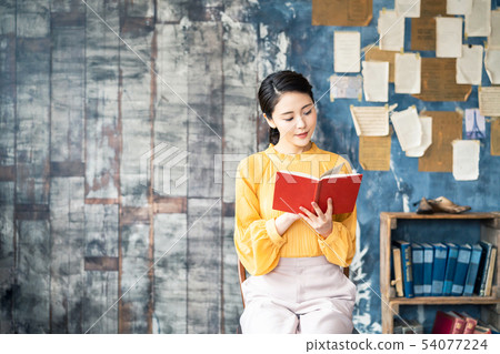 A woman reading a book A woman reading a book 54077224