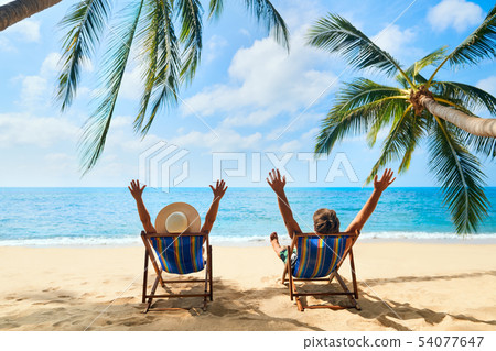 Happy couple with arms up relax on the beach enjoy beautiful sea on the tropical island 54077647