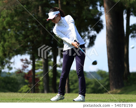 Woman hitting the tee shot Woman hitting the tee shot 54078159