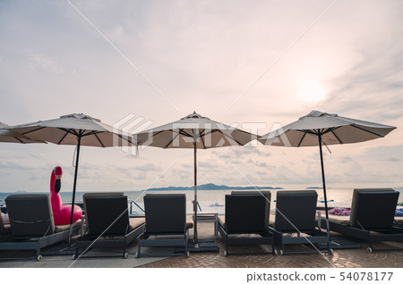 Umbrella with sunbed on infinity pool in tropical 54078177