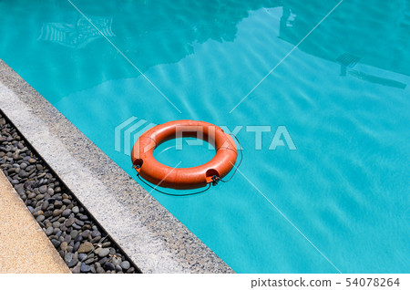 Orange lifebuoy floating on surface swimming pool Orange lifebuoy floating on surface swimming pool 54078264