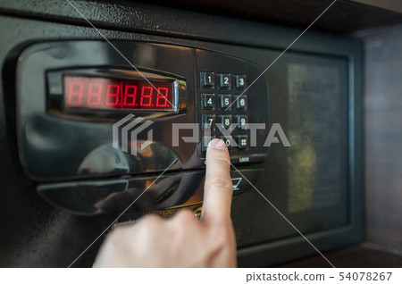 Finger are pressing the number keys of electric 54078267