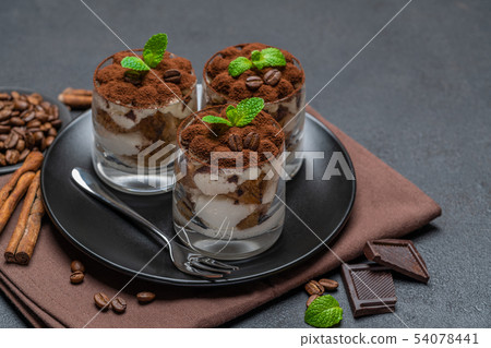 Classic tiramisu dessert in a glass on dark concrete background Classic tiramisu dessert in a glass on dark concrete background 54078441