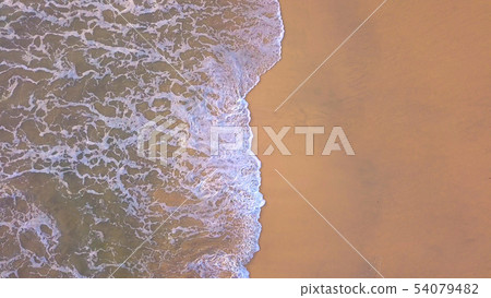 Aerial view of beach with waves rolling into the 54079482