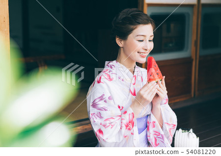 Woman in yukata eating watermelon on vermilion Woman in yukata eating watermelon on vermilion 54081220