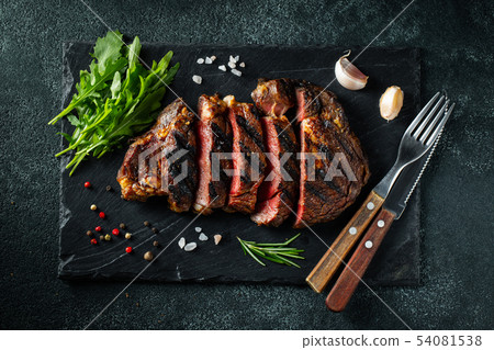Steak ribeye, grilled with pepper and garlic. 54081538