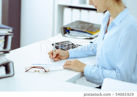 Unknown female bookkeeper or financial inspector calculating or checking balance, making report Unknown female bookkeeper or financial inspector calculating or checking balance, making report 54081929