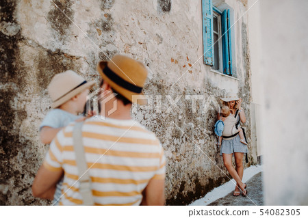 A young family with two toddler children in town on summer holiday. 54082305