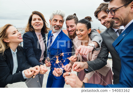 A group of joyful businesspeople having a party outdoors on roof terrace in city. 54083162
