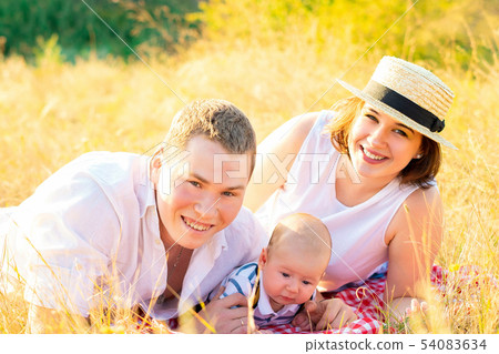 Happy family with little baby spending time together at sunset 54083634