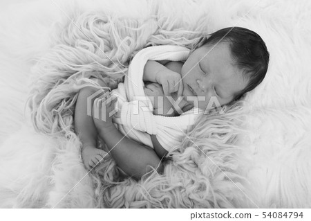 newborn baby sleeps wrapped in a blanket newborn baby sleeps wrapped in a blanket 54084794