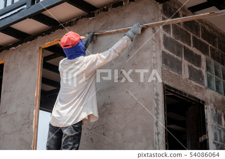 Construction workers plastering building wall Construction workers plastering building wall 54086064