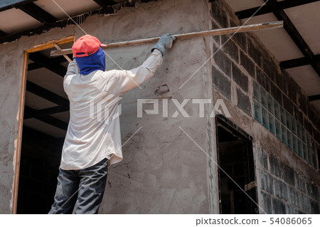 Construction workers plastering building wall Construction workers plastering building wall 54086065
