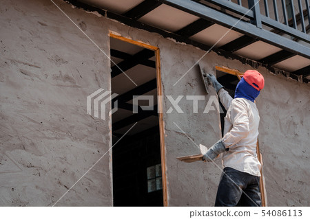 Construction workers plastering building wall Construction workers plastering building wall 54086113