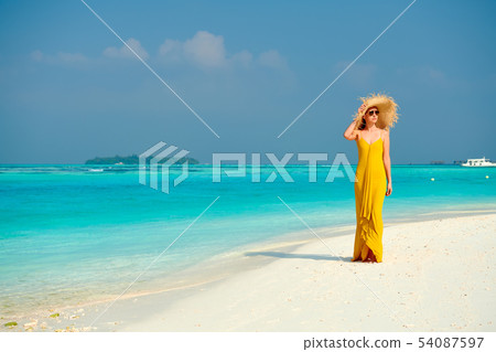 Woman in dress walking on tropical beach Woman in dress walking on tropical beach 54087597