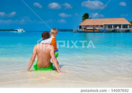 Toddler boy on beach with father 54087692