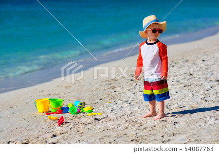 Two year old toddler playing on beach Two year old toddler playing on beach 54087763