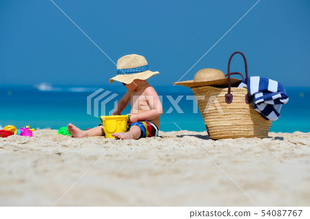 Two year old toddler playing on beach 54087767