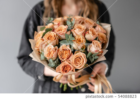 Flowers coffee color, cappuccino roses with eucalyptus. Small Beautiful bouquets in woman hand 54088823