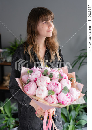 Pink peonies in womans hands. Beautiful peony flower for catalog or online store. Floral shop Pink peonies in womans hands. Beautiful peony flower for catalog or online store. Floral shop 54088935