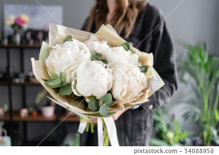 White peonies in womans hands. Beautiful fresh peony flower for catalog or online store. Floral shop 54088958