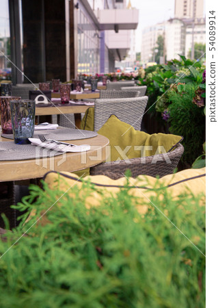 Summer terrace cafe, restaurant. Tables chairs neatly arranged and arranged to serve guests. Summer terrace cafe, restaurant. Tables chairs neatly arranged and arranged to serve guests. 54089914