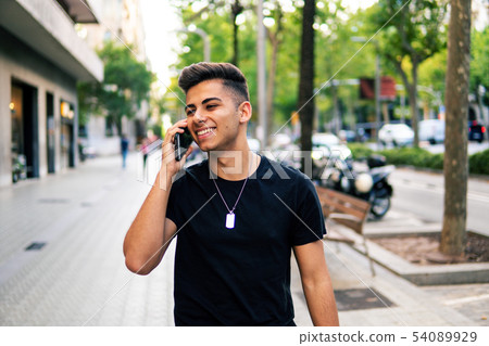 man on the street talking on a cell phone 54089929