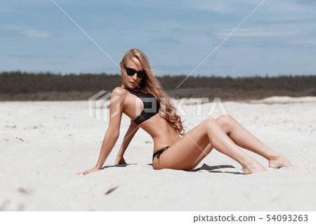 Beautiful young girl in a sexy bikini on the beach Beautiful young girl in a sexy bikini on the beach 54093263
