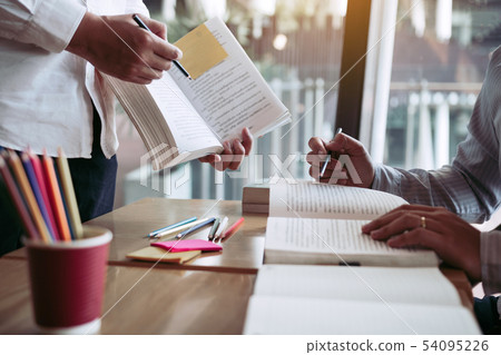 Two student reading textbook for test together in Two student reading textbook for test together in 54095226