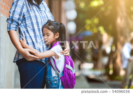 asian pupil girl with backpack hugging her mother asian pupil girl with backpack hugging her mother 54096036