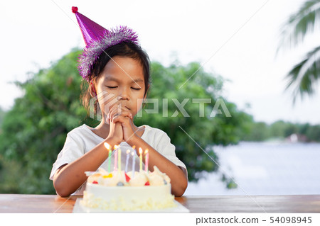 girl make folded hand to wish for her birthday girl make folded hand to wish for her birthday 54098945
