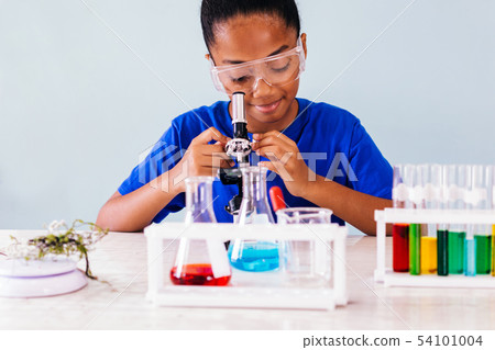 African American kid looking into microscope in laboratory African American kid looking into microscope in laboratory 54101004