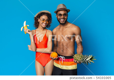Cheerful black man and woman enjoying fresh summer fruits Cheerful black man and woman enjoying fresh summer fruits 54101005