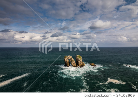 Natural arch of Playa de la Arnia at sunrise, Cantabria, Spain. Natural arch of Playa de la Arnia at sunrise, Cantabria, Spain. 54102909