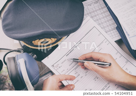 Airplane pilot filling in flight plan Airplane pilot filling in flight plan 54104951