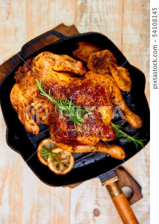 Baked whole chicken with apples in pan  54108145