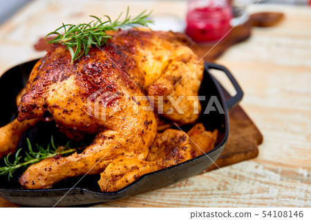 Baked whole chicken with apples in pan  54108146