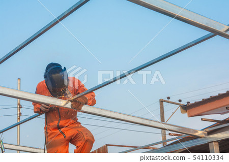 Worker welding in orange work clothes welding For Worker welding in orange work clothes welding For 54110334